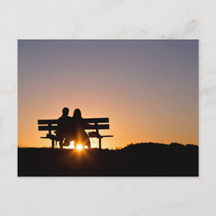 Liefde dacht: een paar zit op een bank als de zon  briefkaart