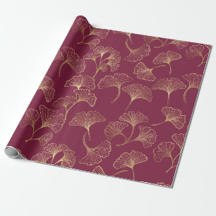 Luxe gouden ginkobladeren op dieprood cadeaupapier