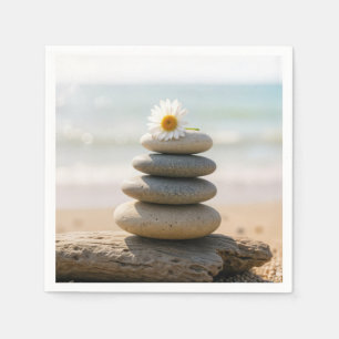 Madeliefje op een stenen strandcairn met drijfhout servet