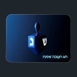 Magnet Flexible Dreidel bleu brillant<br><div class="desc">Un rêve moderniste bleu métallique contre un arrière - plan sombre et nocturne. Deux des lettres hébraïques trouvées sur un dreidel,  une nonne et un shin,  brillent brillamment. Le texte hébreu "Chag Chanukkah Sameach" (Hanoukka heureuse) apparaît également en bleu et blanc éclatant.</div>