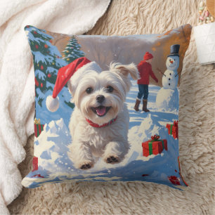 Maltezer hond rent in de sneeuw met kerstmuts kussen