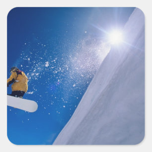 Man die door de lucht vliegt op een snowboard met vierkante sticker