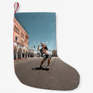 Man die skateboard speelt kleine kerstsok