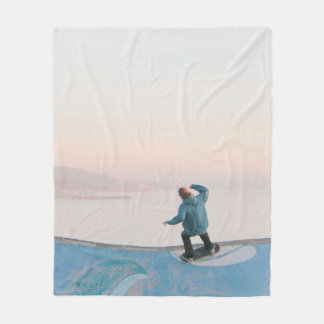 Man in blue skateboarding on wall in beach fleece deken