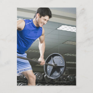Man in de gymzaal, grote barbel optillen, klemmen briefkaart
