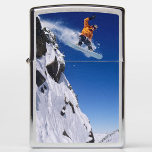 Man op een snowboard die van een richel springt bi