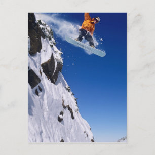 Man op een snowboard die van een richel springt bi briefkaart