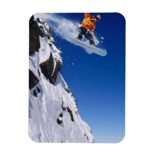 Man op een snowboard die van een richel springt bi magneet