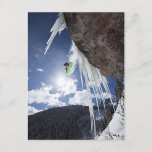 Mannelijk snowboarder springt van een ijswaterval briefkaart