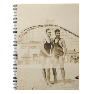 Mannen die op strand staan notitieboek