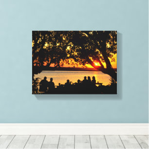 Mensen aan de rand van de rivier bij zonsondergang canvas afdruk