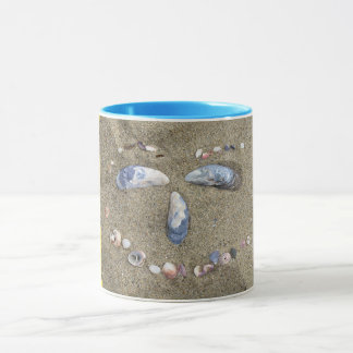 Mok gele zijde gemaakt in zand met zeeschelpen