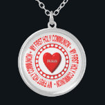 Mon premier collier de communion<br><div class="desc">Ce collier comporte un hôte entouré de chapeaux et portant un coeur "3D" d'apparence au milieu avec le nom de Jésus dessus. Tout cela est entouré des mots "Ma première sainte communion".</div>