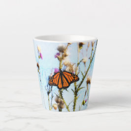 Monarch Butterfly op Paarse Thistle Struik Latte Mok