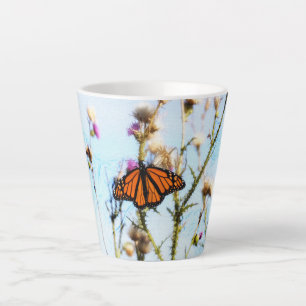 Monarch Butterfly op Paarse Thistle Struik Latte Mok