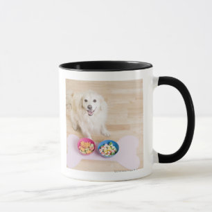 mongrel zit voor twee kom met hond mok