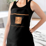 Monogramme élégant noir nom de script tablier<br><div class="desc">Tablier design monogrammed exclusif de luxe avec un carré de parties scintillant métallique en cuivre faux or et lignes sur un arrière - plan noir solide élégant et élégant.              Personnalisez-le avec votre nom de famille ou votre nom de famille et votre nom monographique initial.</div>