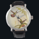 Montre Deux colibris colorés qui veulent la même fleur<br><div class="desc">L'artiste John Gould était passionné par les oiseaux. Dans ce dessin coloré,  les deux colibris et la fleur sont magnifiquement représentés. Les détails de ce bel art coloré raviront les amateurs d'art.</div>