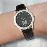 Montre Élégant Monogramme d'or noir moderne<br><div class="desc">Monogramme personnalisé Monogramme noir et blanc avec chiffres blancs simples. Cette montre épurée et minimaliste allie style classique et touche personnelle, avec une initiale audacieuse de couleur or (note : l'or est une couleur plate sans éclat) sur un visage noir, accentuée par des chiffres blancs simples pour une lecture facile....</div>