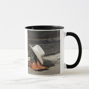 Mug Casquette de cowboy sur des bottes de cowboy en