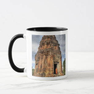 Mug moine bouddhiste debout dans l'encadrement de la p