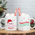 Mug Père Noël Happy Face Vibes de Noël personnalisées<br><div class="desc">Ce visage heureux Père Noël est le cadeau parfait pour les vacances! Il est personnalisé avec votre nom et dispose d'un visage rose heureux avec un chapeau de Père Noël et de mignons détails de starburst sur un côté et le texte Chrismtas Vibes dans une police rétro sur l'autre. C'est...</div>