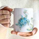 Mug Plage Noël Mer Tortue Mer & Salutations<br><div class="desc">Cette tasse à café de Noël à la plage dispose d'une tortue de mer aquarelle avec des sprigs de verdure de vacances et des baies rouges. Les mots "Seas & Greutations" sont placés dans la typographie de script rouge à la mode. Un choix charmant pour votre décor de vacances ou...</div>