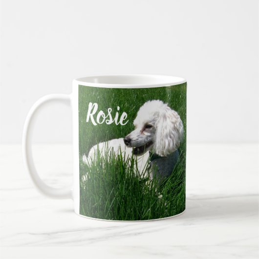 Mug Un caniche blanc reposant dans l'herbe verte luxur (Gauche)