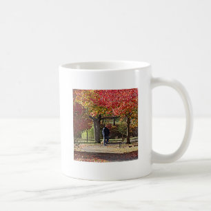 Mug Un homme marche chien dans le parc d'automne