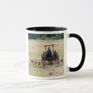 Mug Un jeune garçon conduisant une moisson de tracteu