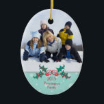 Noël saint personnalisable ornement photo de famil<br><div class="desc">Cet ornement en céramique de forme ovale a un design de vacances de Noël. En bas,  il y a un buisson à baies vitrées avec l'année et le nom de famille qui est facilement personnalisable avec votre texte. En haut,  vous pouvez ajouter votre propre photo. Copyright © Sarah Paris</div>