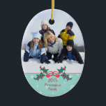 Noël saint personnalisable ornement photo de famil<br><div class="desc">Cet ornement en céramique de forme ovale a un design de vacances de Noël. En bas,  il y a un buisson à baies vitrées avec l'année et le nom de famille qui est facilement personnalisable avec votre texte. En haut,  vous pouvez ajouter votre propre photo. Copyright © Sarah Paris</div>