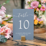 Numéro De Table Chic Script Dusty Blue Wedding Réception<br><div class="desc">Élégant panneau de numéro de table de mariage bleu poussiéreux avec "table" dans un script de calligraphie blanc élégant avec des swashes, le numéro de table en élégante typographie serif blanche, vos prénoms unis par un coeur et votre date de réception. Créez chaque signe de numéro de table et ajoutez-le...</div>