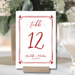 Numéro De Table Mariage rouge blanc tiré à la main<br><div class="desc">Elégant Mariage Whimsical Dessiné À La Main Numéro De Table. Cette adorable carte numérique de table présente un cadre subtil et dessiné à la main avec des coeurs noirs dans chaque coin, créant un design amusant mais élégant qui encercle délicatement le numéro de table. Le mélange de polices manuscrites et...</div>