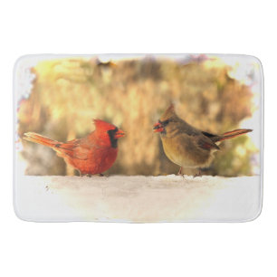 Oiseaux cardinaux dans des tapis de bain d'automne