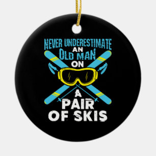 Onderschat nooit een paar skis van een oude man keramisch ornament