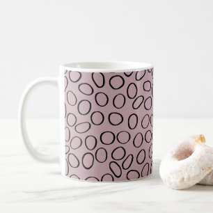 Onregelmatig zwart cirkelpatroon op roze koffiemok