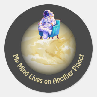 Ontspannen astronaut zittend op planeet ronde sticker