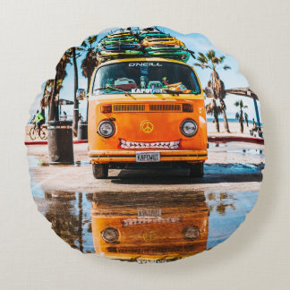 Oranje bestelwagen met surfplank bovenaan rond kussen