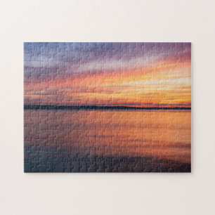Oranje en paarse zonsondergangswolken boven meerwa legpuzzel