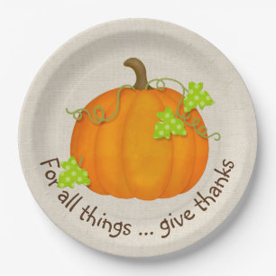 Oranje pompoen op schoot papieren bordje