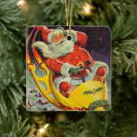 Ornement En Céramique Noël vintage, le Père Noël dans un vaisseau spatia<br><div class="desc">Illustration vintage image de Noël montrant un Père Noël rétro des années 50 volant un vaisseau spatial de science-fiction au-dessus d'une ville endormie la veille de Noël.</div>