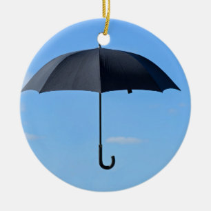 Ornement En Céramique Parapluie noir vole dans le ciel bleu