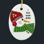 Ornement En Céramique Snowman en Casquette rouge et écaille verte<br><div class="desc">Un mignon bonhomme de neige avec un nez de carotte et des joues roses. Un casquette rouge,  des oreilles et une écharpe verte. Le dicton peut être changé à volonté.</div>