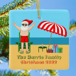 Ornement En Céramique Sunny Beach Santa Claus Cute Custom Christmas<br><div class="desc">This cute custom Christmas in July ornament makes perfect summer party decor for a beach bash or pool gathering. Make it a fun north pole themed extravaganza with Santa Claus in his swimming trunks next to a red and white striped beach umbrella and gifts. I've never seen Mr. Klaus in...</div>
