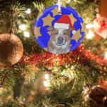 Ornement En Verre Chien de gingembre à Santa Hat | Étoiles d'or sur<br><div class="desc">Un ornement de Noël personnalisé est une excellente façon de célébrer votre animal de compagnie à Noël. Un dessin d'un chapeau de Père Noël rouge et blanc est placé sur la photo d'un chien du Queensland Heeler gingembre. L'arrière - plan est rempli d'étoiles d'or sur un arrière - plan bleu....</div>