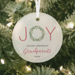 Ornement En Verre Joy Wreath Notre premier Noël en grands-parents<br><div class="desc">Élégant ornement de vacances avec "JOY" avec les lettres "J" et "Y" dans une police sans serif rouge et une feuille de verdure aquarelle peinte comme lettre "O". Ci-dessous est "Notre premier Noël en tant que grands-parents" avec l'année. Ce joli ornement est un cadeau parfait pour les nouveaux grands-parents.</div>