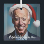 Ornement En Verre Le président Joe Biden et Santa Hat<br><div class="desc">Ce dessin présente une caricature de Joe Biden portant un chapeau de Père Noël sur un arrière - plan bleu.</div>