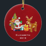 Ornement Rond En Céramique Santa and Reindeer par Christmas Tree with Present<br><div class="desc">Une jolie illustration avec l'esprit de fête. Le Père Noël portant son sac cadeau et saluant. Son ami renne à ses côtés, suspendu par un sapin décoré, avec des cadeaux tout autour. Placez-vous sur un arrière - plan rouge. Design festif et gai. Personnalisez avec un nom et une année ou...</div>