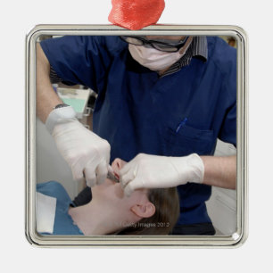 Orthodontist die de gebitsbeugels van een metalen ornament